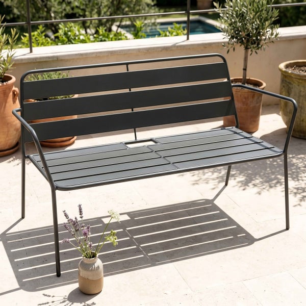Moderne Gartenbank aus Metall mit Armlehnen und Latten-Design in Anthrazit auf einer hellen Terrasse.