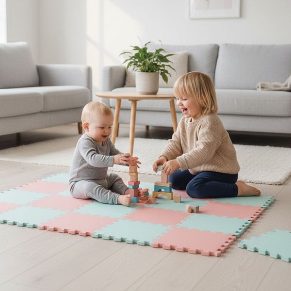 Zwei Kinder spielen mit Holzbausteinen auf einer weichen Puzzle-Spielmatte in einem hellen, modern eingerichteten Wohnzimmer.