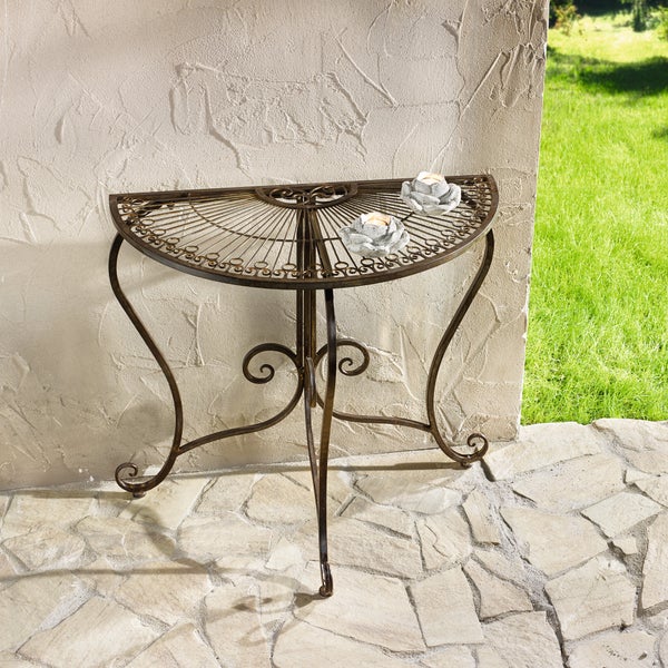 Halbrundes Metallbeistelltisch mit dekorativen Kerzenhaltern im Außenbereich.