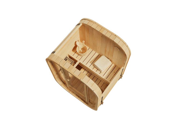 Draufsicht einer Fasssauna aus hellem Holz mit Holzbänken, Saunakübel mit Kelle und Handtuch im Innenraum.