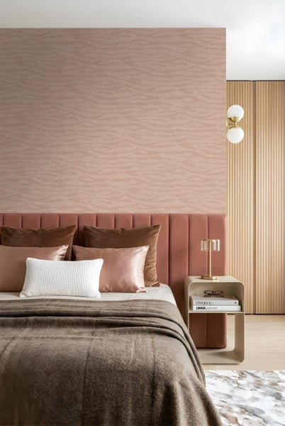 Modernes Schlafzimmer mit gemusterter Vliestapete, gepolstertem Kopfteil, Beistelltisch und dekorativen Wohnaccessoires.