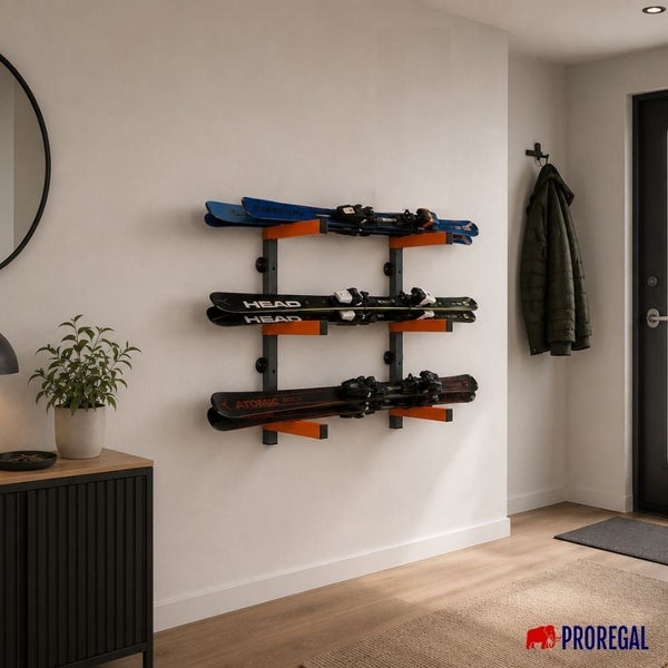 Wandmontierter Skihalter aus Metall für drei Paar Ski in einem hellen, modern organisierten Flur mit Sideboard und Pflanze. Proregal Logo.