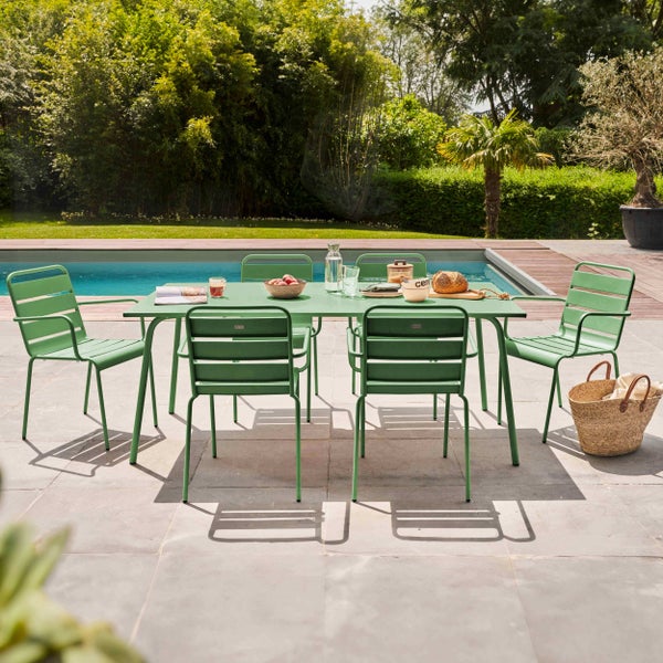Moderne grüne Garten-Essgruppe aus Metall mit rechteckigem Tisch und sechs Lattenstühlen auf einer Terrasse neben einem Pool.