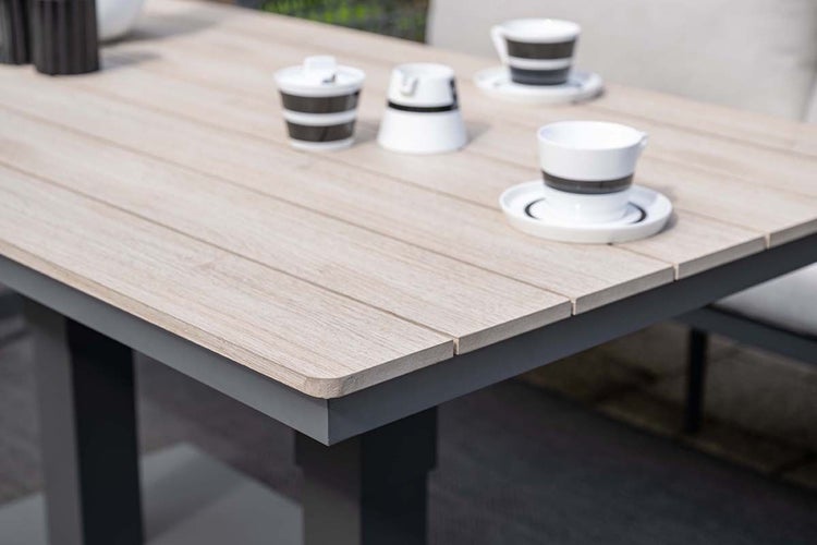 Gartentisch mit Tischplatte in Holzoptik und dunklem Metallgestell, Detailansicht mit Kaffeetassen.
