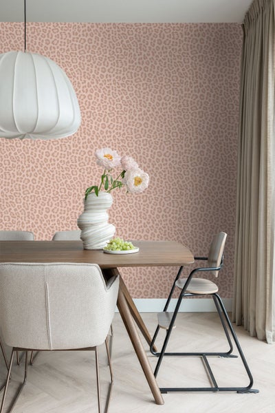 Modernes Esszimmer mit Tapete in Leoparden-Optik, Holztisch, Polsterstuhl und Hängeleuchte.