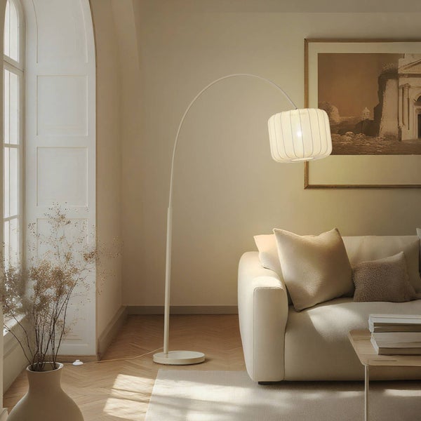 Wohnzimmer mit Bogenlampe, Sofa, Kissen und Dekoration