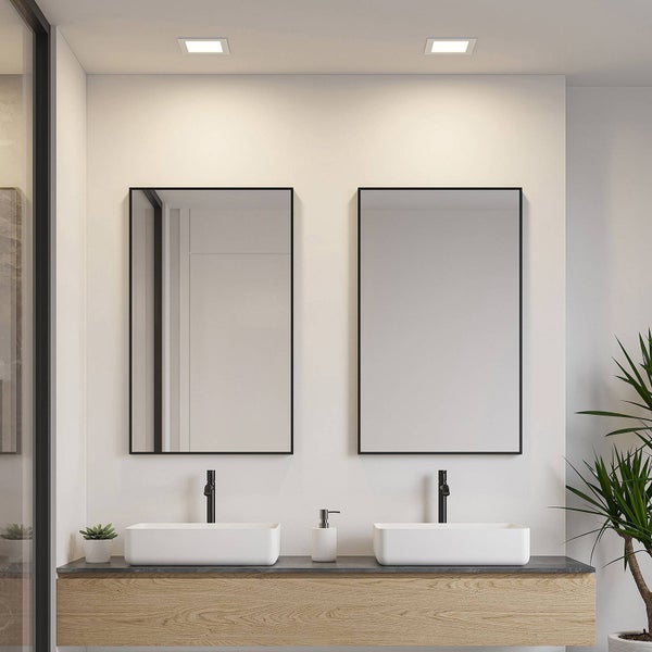 Modernes Badezimmer mit zwei rechteckigen Spiegeln mit schwarzem Rahmen, weißen Aufsatzwaschbecken und schwarzen Armaturen auf einem Holzunterschrank.