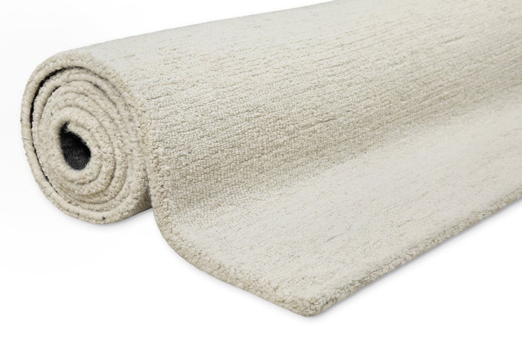 Cremefarbener Hochflor-Teppichboden als Rolle mit weicher, flauschiger Textur.