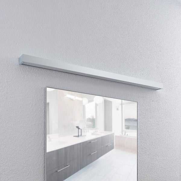 Moderne rechteckige Badspiegelleuchte in Chrom, montiert über einem Spiegel an einer strukturierten Wand.