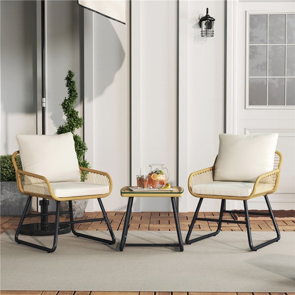 Terrasse mit zwei Rattansesseln, Kissen und Beistelltisch mit Getränken