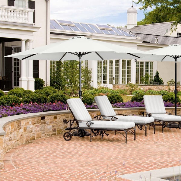 Szene mit drei Liegestühlen mit Sonnenschirmen im Garten