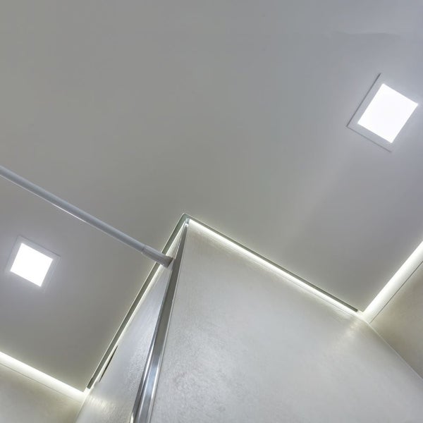 Badezimmer mit Deckenleuchten und Duschkabine