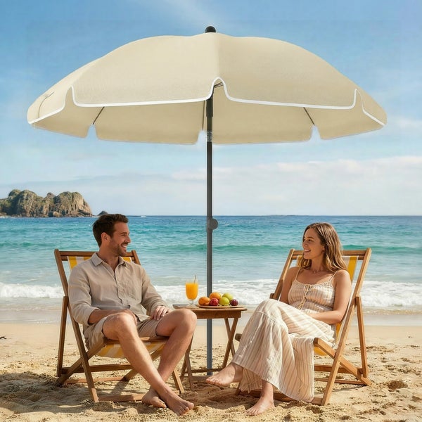 Zwei hölzerne Sonnenliegen mit beigen Polstern unter einem großen beigen Sonnenschirm an einem sonnigen Sandstrand.