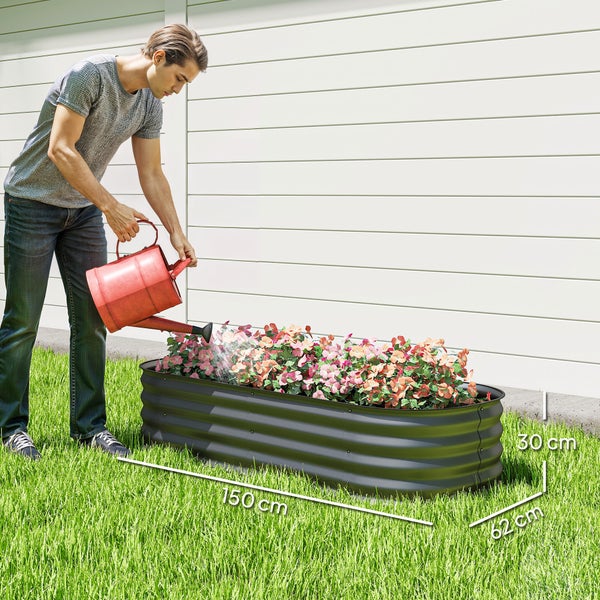 Ovales Hochbeet aus gewelltem Metall bepflanzt mit gelben Blumen auf einer Rasenfläche vor einem Wohnhaus.