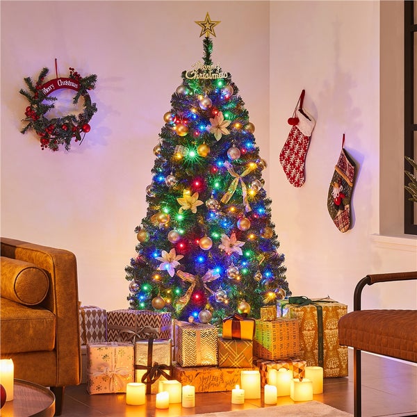 Dekorierter Weihnachtsbaum mit Geschenken, Kranz und Weihnachtssocken in einem gemütlichen Raum.