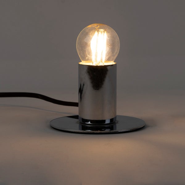 Minimalistische Tischleuchte aus verchromtem Metall mit leuchtender LED-Filament-Birne.