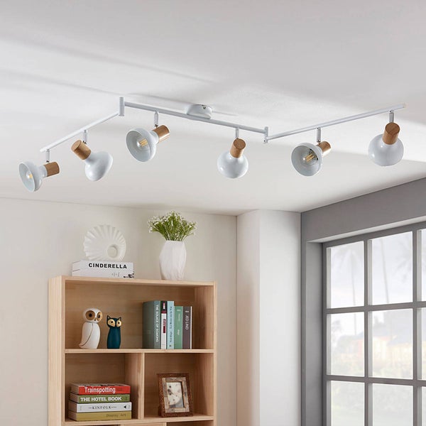 Deckenleuchte mit sechs Strahlern, Holzdetails und Bücherregal im Raum.