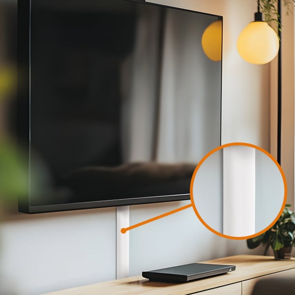Ein weißer Kabelkanal zur Wandmontage unter einem Flachbildfernseher mit Detailansicht der glatten Oberfläche und des modernen Designs.