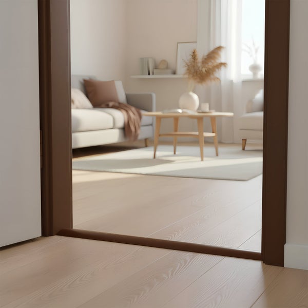 Dunkelbraune Türschwelle in einem hellen Wohnraum mit Holzboden und Blick in ein modern eingerichtetes Wohnzimmer.