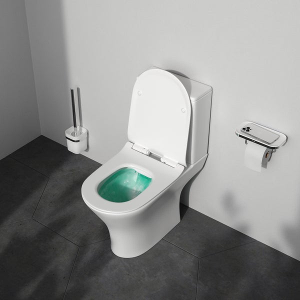 Ein weißes WC mit offenem Deckel, Toilettenbürste und Toilettenpapierhalter im Badezimmer.