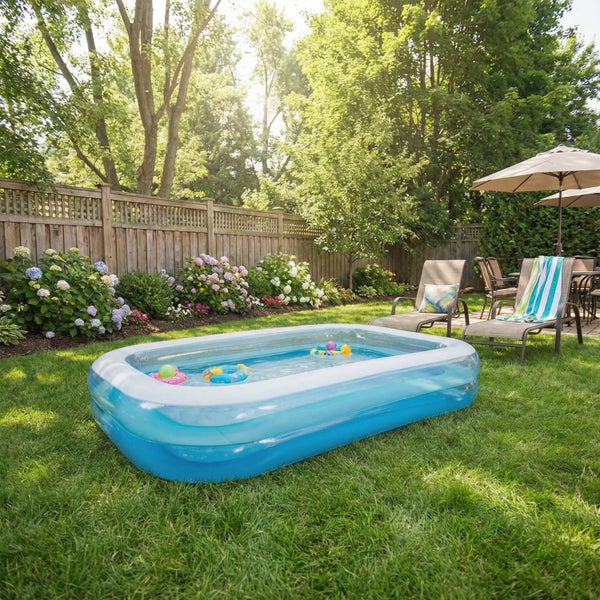 Aufblasbarer rechteckiger Familienpool auf einer Gartenwiese mit Gartenmöbeln und blühenden Hortensien im Hintergrund bei sonnigem Wetter.