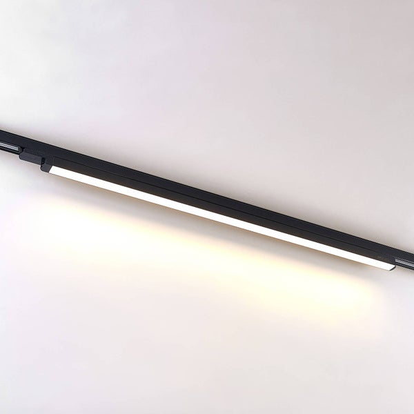 Schwarze LED-Schienenleuchte von Arcchio in länglicher Form mit eingeschaltetem warmweißem Licht.