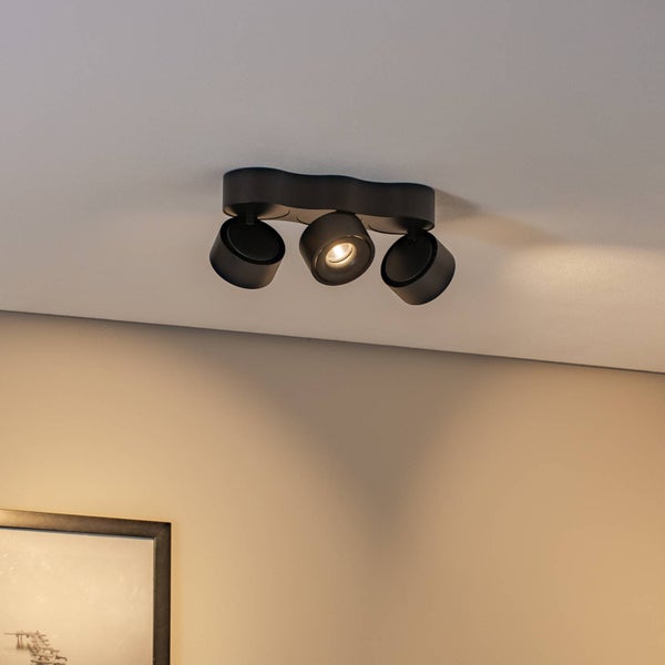 Moderner Deckenstrahler mit drei schwarzen Lampen, montiert an der Decke, ein Licht ist eingeschaltet.