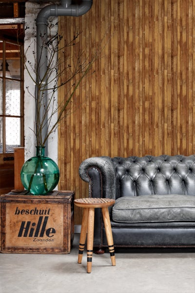 Innenaufnahme mit Chesterfield-Sofa, Holzhocker und dekorativer Holzkiste