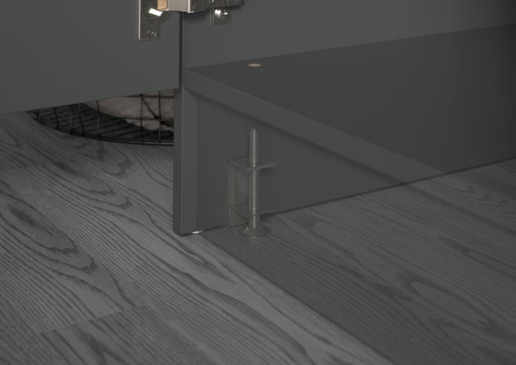Verstellbarer Möbel Sockelfuß zur Höhenregulierung an einem Schrank auf Holzfußboden.