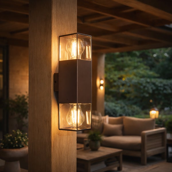 Moderne rechteckige Außenwandleuchte mit zwei Filament-Glühlampen an einem Holzpfosten auf einer beleuchteten Terrasse.