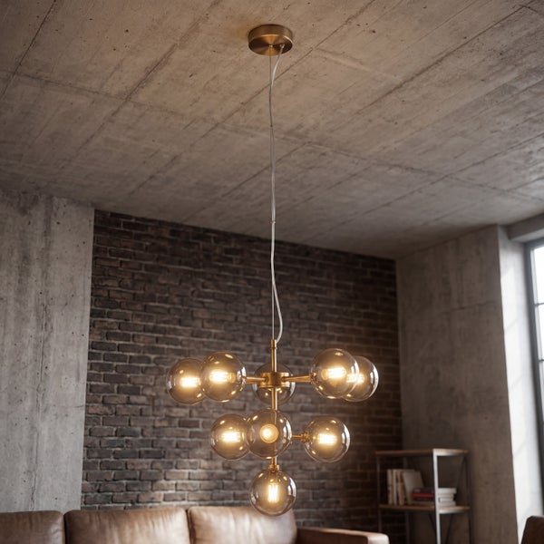 Pendelleuchte mit runden Glasschirmen und Metallgestell in einem industriellen Wohnraum mit Sichtbeton und Ziegelwand.