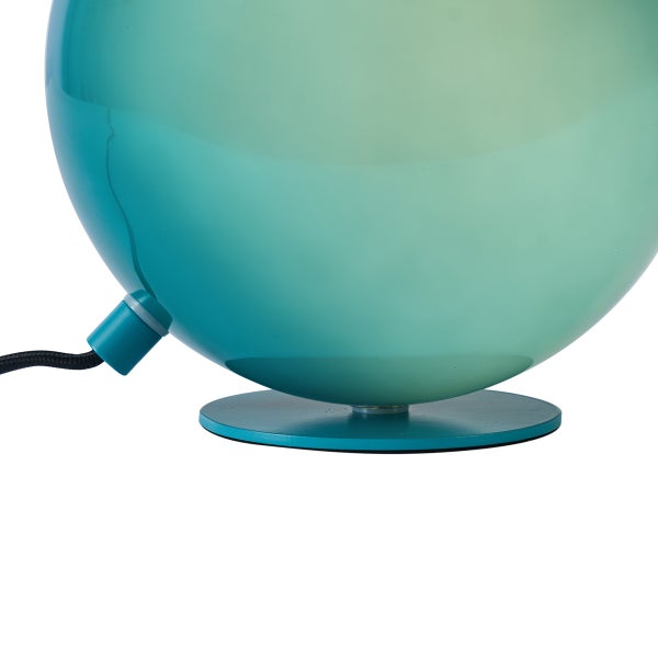 Kugelförmige Tischleuchte aus Glas mit türkisfarbenem Farbverlauf, flachem Sockel und schwarzem Kabel.