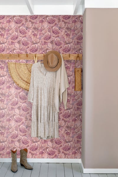 Dekorativer Raum mit floraler Tapete, Kleidung und Accessoires an der Wandgarderobe