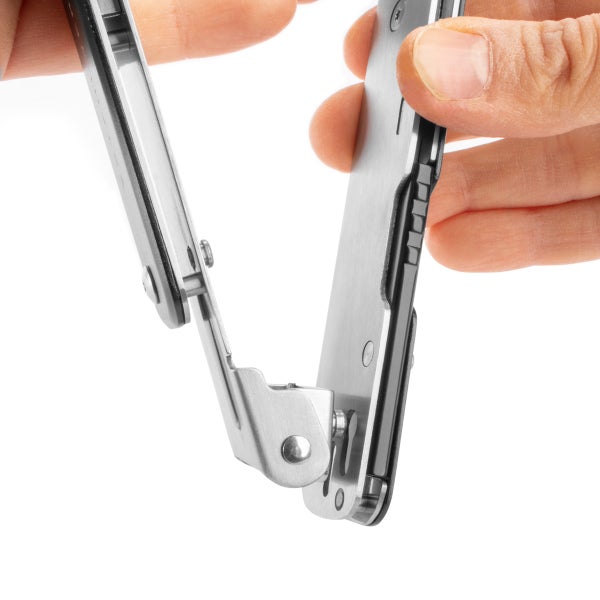 Nahaufnahme eines Gelenkmechanismus an einem Multitool aus Edelstahl, der mit den Händen bedient wird.