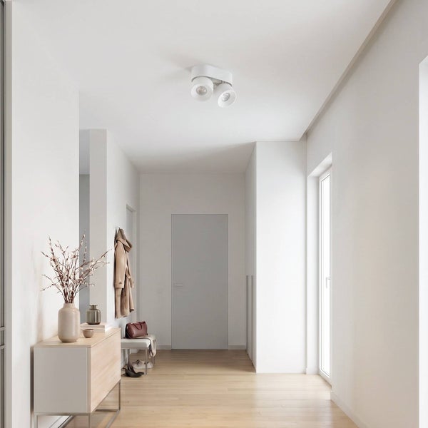 Heller Flur mit Holzboden, minimalistischer Kommode und modernem Deckenstrahler als Deckenleuchte.