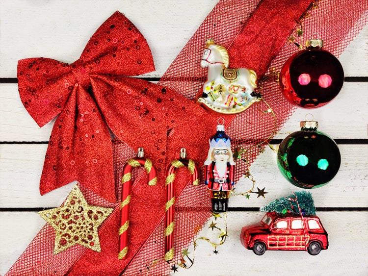 Esstisch mit burgunderrotem Tischläufer, Geschirr und Blumenvase für eine festliche Tischdekoration.