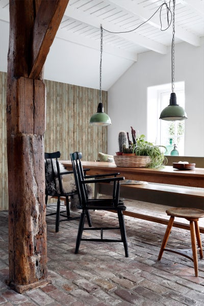 Rustikaler Essbereich mit Holztisch, Stühlen, Pendelleuchten und Holzsäule