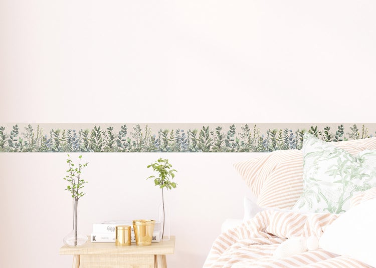 Tapetenbordüre mit botanischem Muster an einer Wand in einem hellen Schlafzimmer über einem Nachttisch und einem Bett.