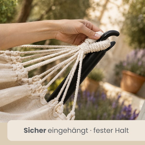 Hand hängt die Seile einer Hängematte für einen sicheren Halt an einem Metallhaken des Gestells ein.