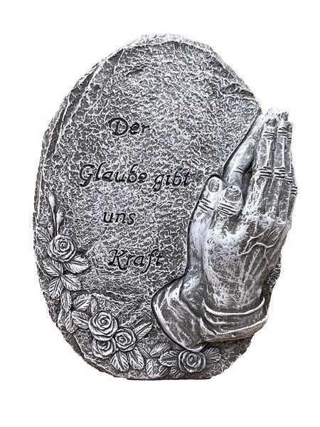 Grabschmuck in Form eines ovalen Steins mit betenden Händen, Rosenrelief und der Inschrift Der Glaube gibt uns Kraft.