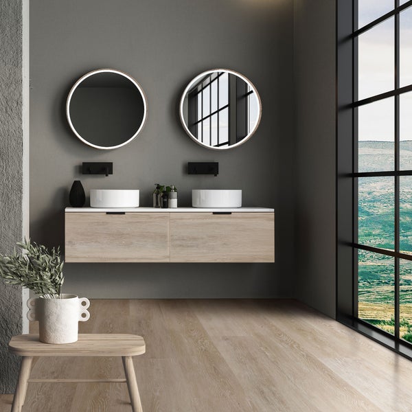 Modernes Badezimmer mit Doppelwaschtisch, zwei runden beleuchteten Spiegeln und Holzunterschrank vor großem Fenster mit Landschaftsblick.