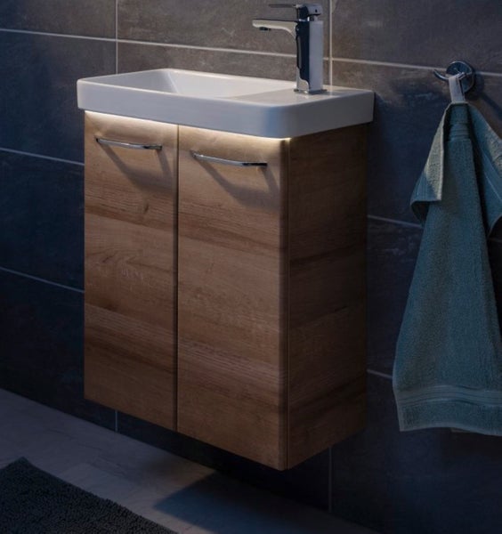Waschtisch mit Unterschrank, Armatur und Handtuch im Badezimmer