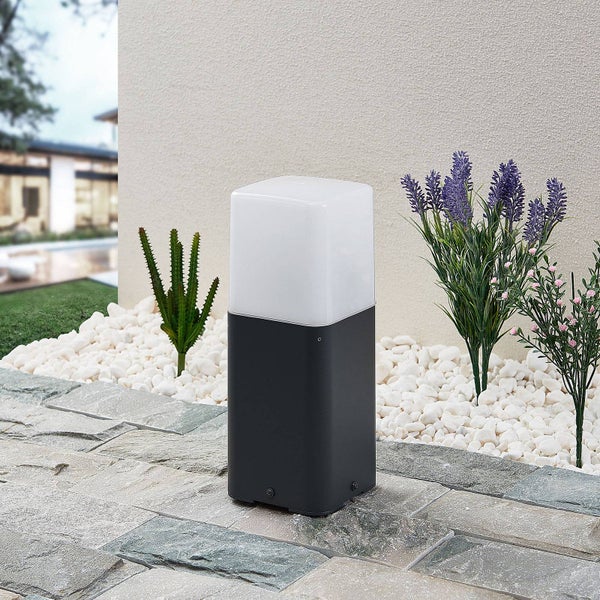 Außenleuchte mit quadratischem Lampenschirm und dunklem Sockel auf Steinfliesen