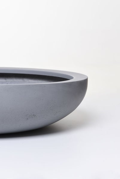 Graue Pflanzschale in runder Form aus Kunststoff-Stein-Gemisch in Betonoptik.