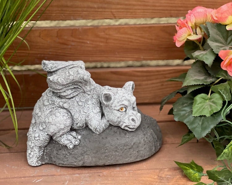 Gartenfigur liegender Drache auf einem Stein, dekorative Drachenfigur aus Steinguss für den Außenbereich.