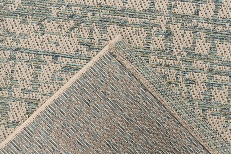 Strukturdetail eines gewebten Teppichs mit umgeschlagener Ecke für einen Blick auf die Rückseite.