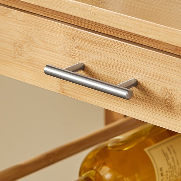 Detailaufnahme eines Schubladengriffs aus Metall an einem Holzmöbelstück.