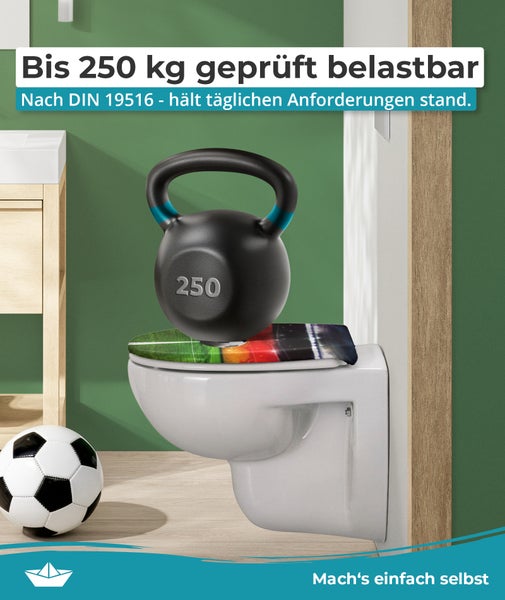 Wand-WC mit Fußball-Toilettensitz, belastbar bis 250 Kilogramm gemäß DIN 19516, im Badezimmer mit Fußball neben dem WC.