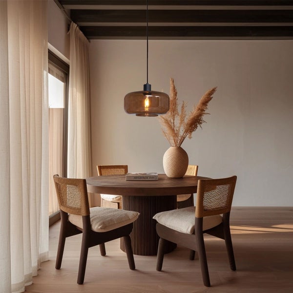 Esszimmer mit Pendelleuchte über einem runden Holztisch und Stühlen