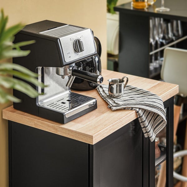 Espressomaschine auf einer Kücheninsel mit Holzplatte und dunklen Schrank